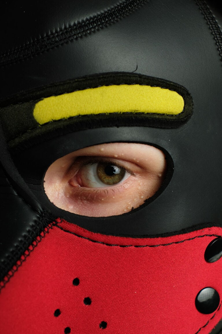 Nahaufnahme von Pup Kaleis Auge. Er trägt seine schwarze Hood, für die Augenbraue ist eine gelbe Applikation aufgenäht, über der Wange eine rote. Foto: Stefan Nieland