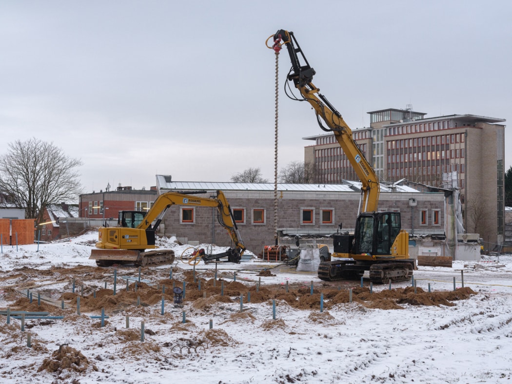 Schneebedeckte Baustelle mit zwei Baggern und Bohrmaschinen, wie sie im Rahmen von Bombenentschärfungen eingesetzt werden.