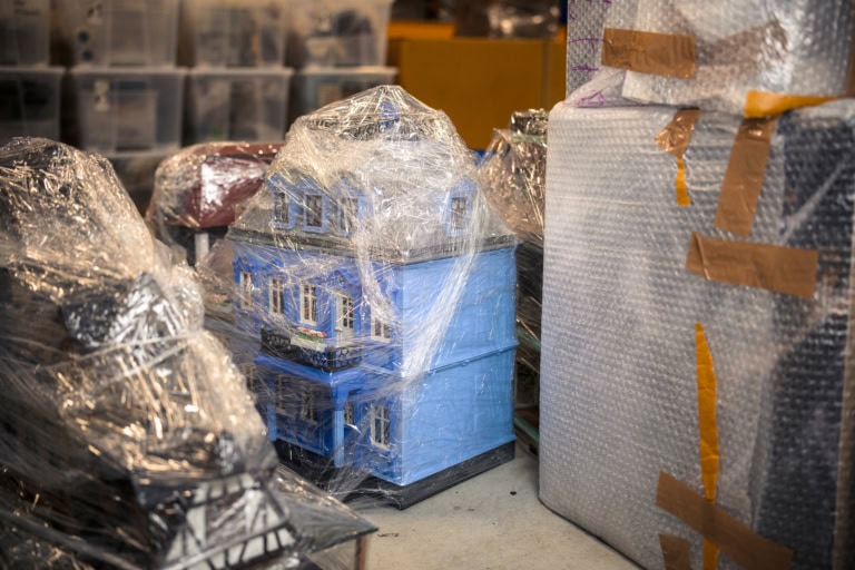 Von seinen Ausstellungen kommen die Playmobil Häuser in Frischhaltefolie gewickelt zurück in Diorama Künstler Oliver Schaffers Hochregal Lager.