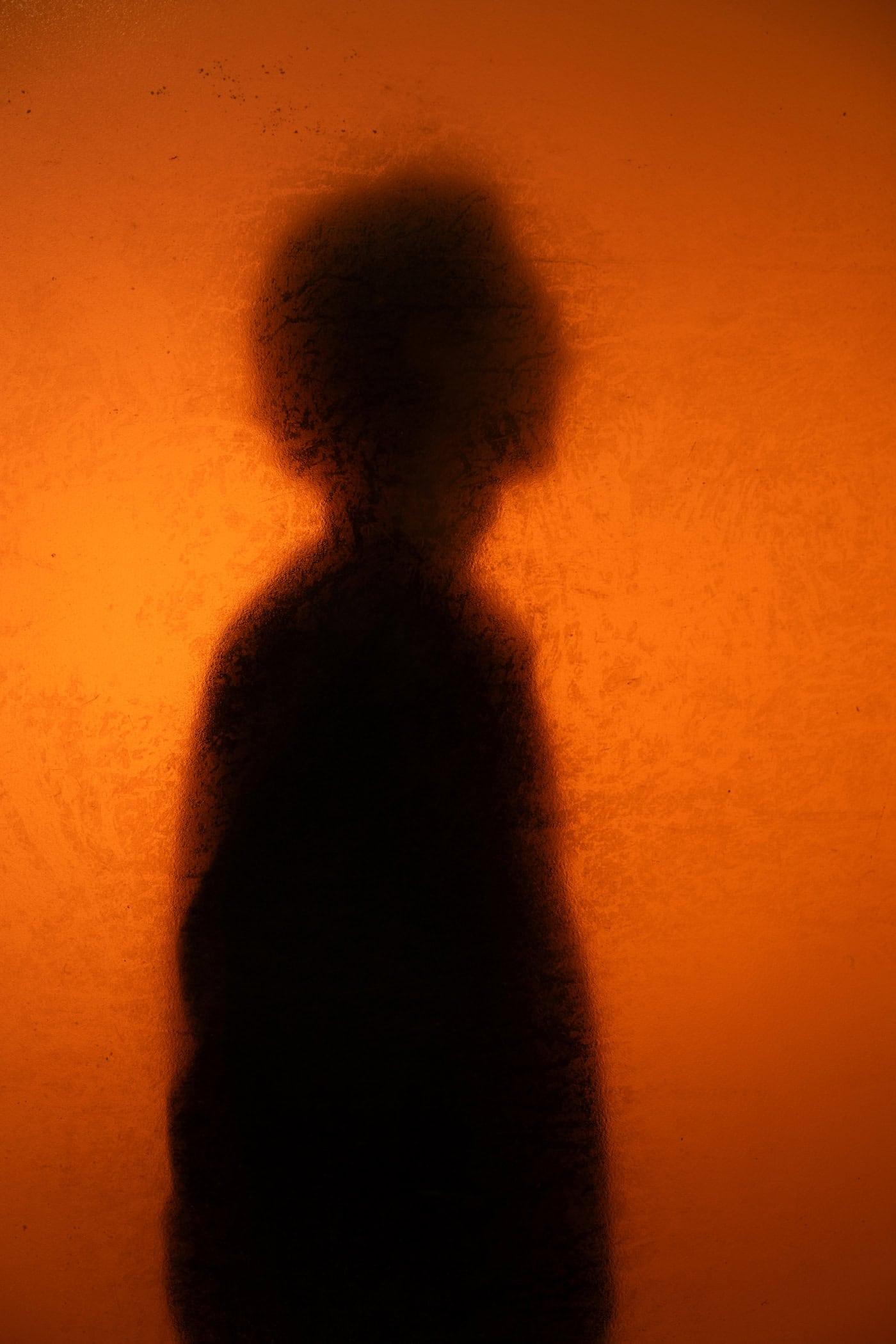 unscharfe Silhouette vor leuchtendem orangenem Hintergrund