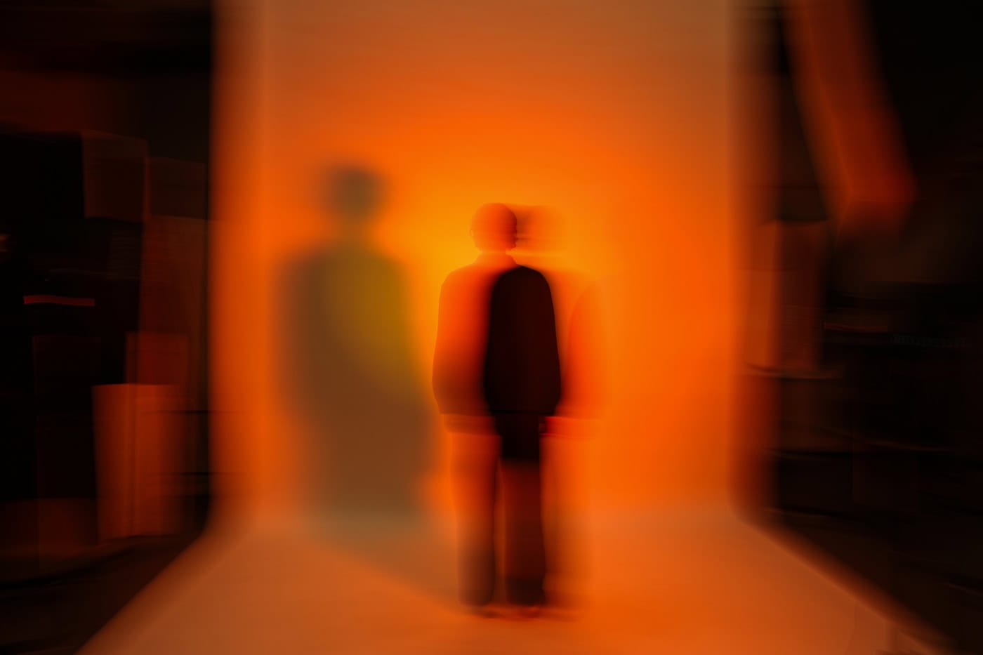 unscharfe Ganzkörper Silhouette vor orangenem Hintergrund