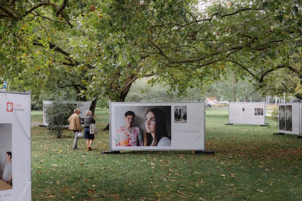 Besucherinnen und Besucher betrachten die Fotokabinen der Ausstellung Demenz in Beziehung