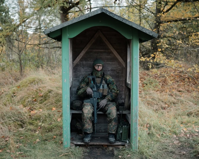 Soldier with a rifle in a guardhouse at the entrance to a firing range