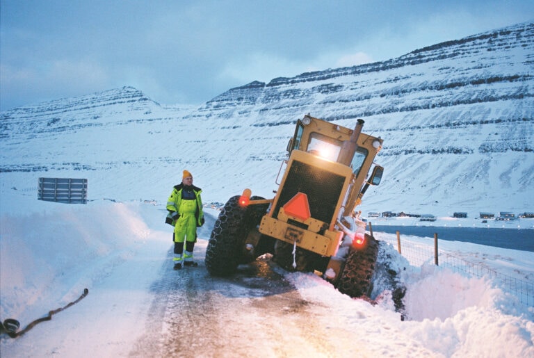 Ein Arbeiter steckt mit seinem Schneeräumfahrzeug im Straßengraben fest, da es während einer ungewöhnlich langanhaltenden Kältephase zu starken Schneefällen gekommen ist.