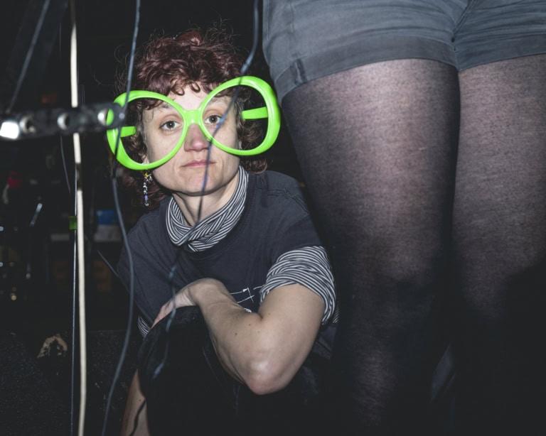 Mit einer überdimensionierten neongrünen Brille sitzt Alex, das Gesangsorgan von «Das Günther» vor uns und blickt in die Kamera.