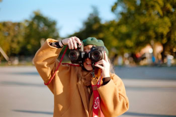 Eine Frau hält sich zwei Kameras vor die Augen.